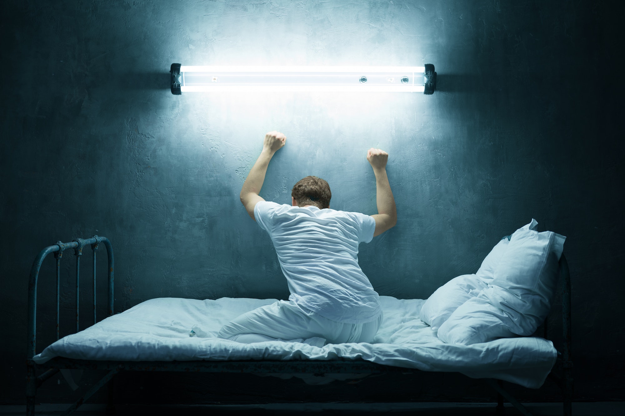 Psycho man alone in bed, dark room, hospital