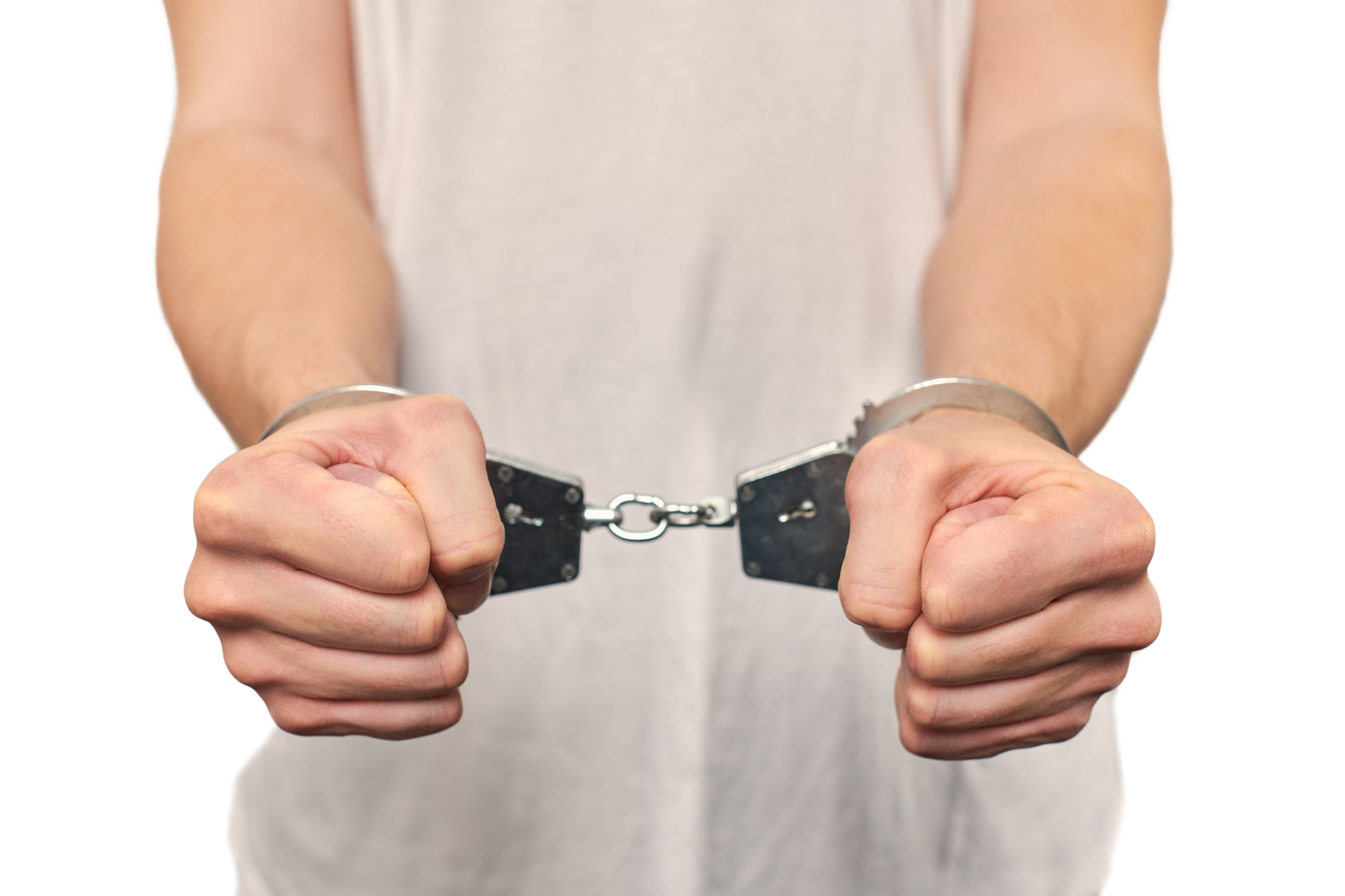 Hands of criminal in handcuffs, arrest of dangerous criminal, violation of law, white background