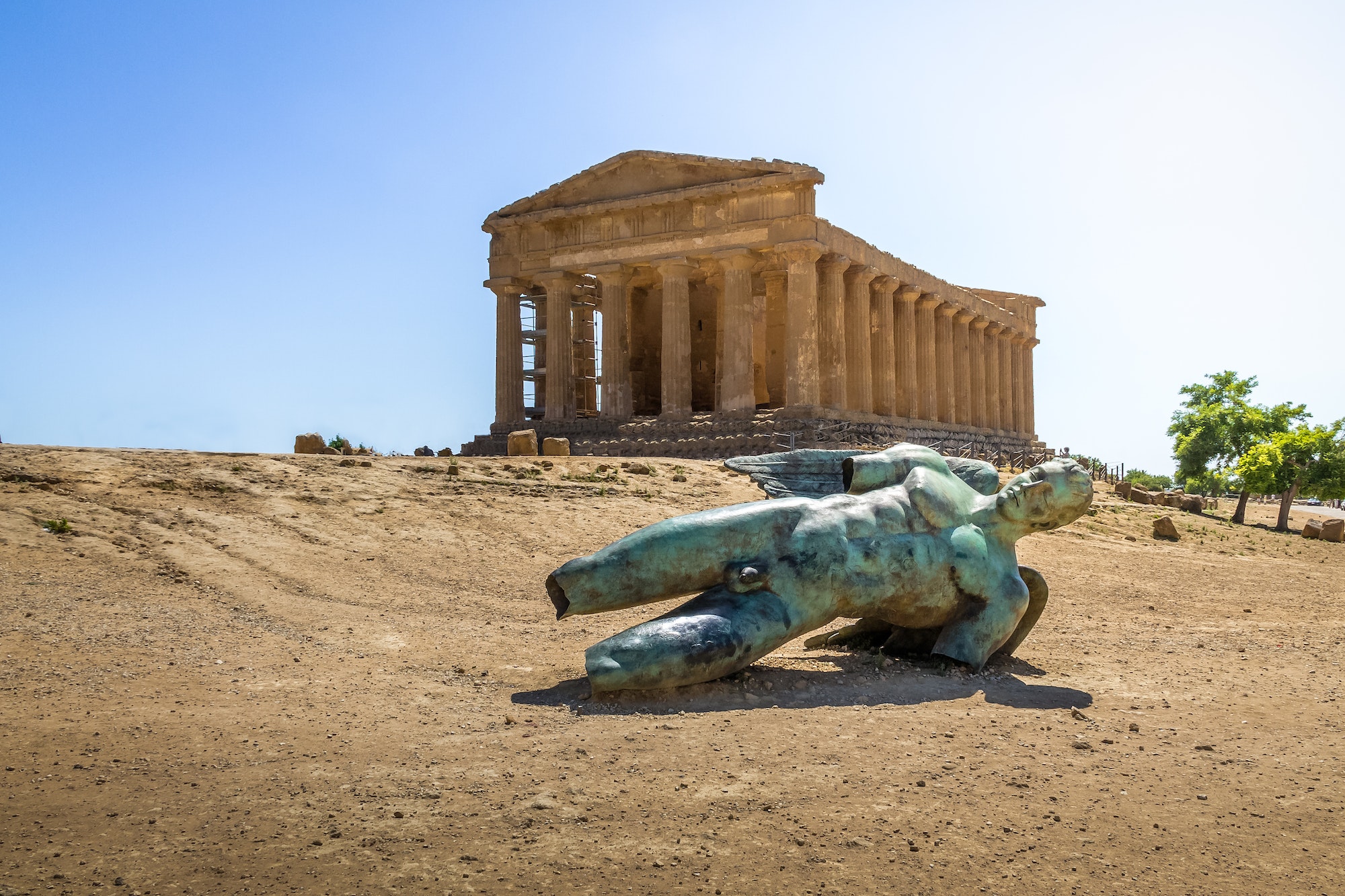 Icarus bronze statue and Temple of Concordia in the Valley of Temples - Agrigento, Sicily, Italy