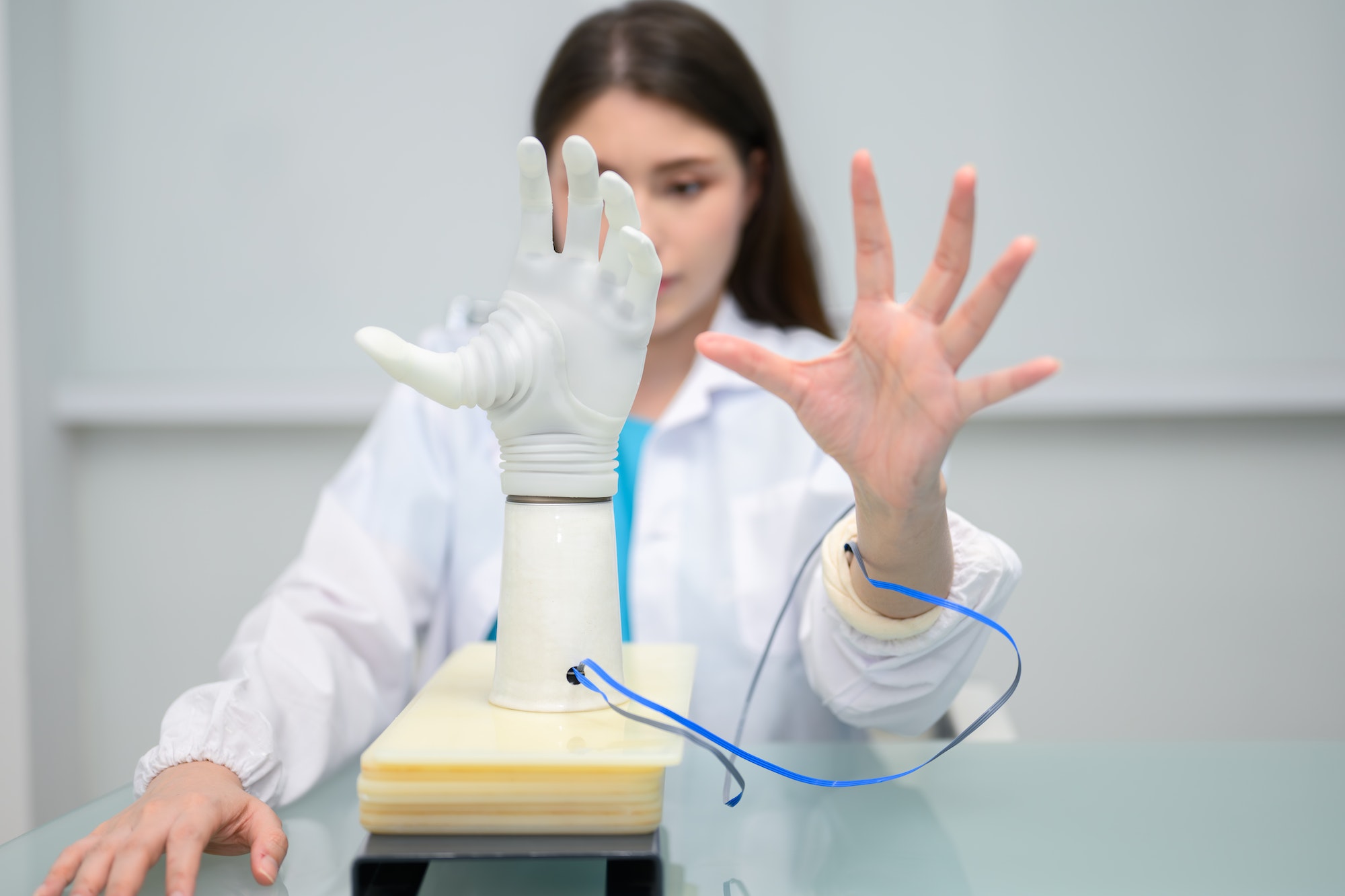 Technician testing robotic bionic arm at prosthetic manufacturing